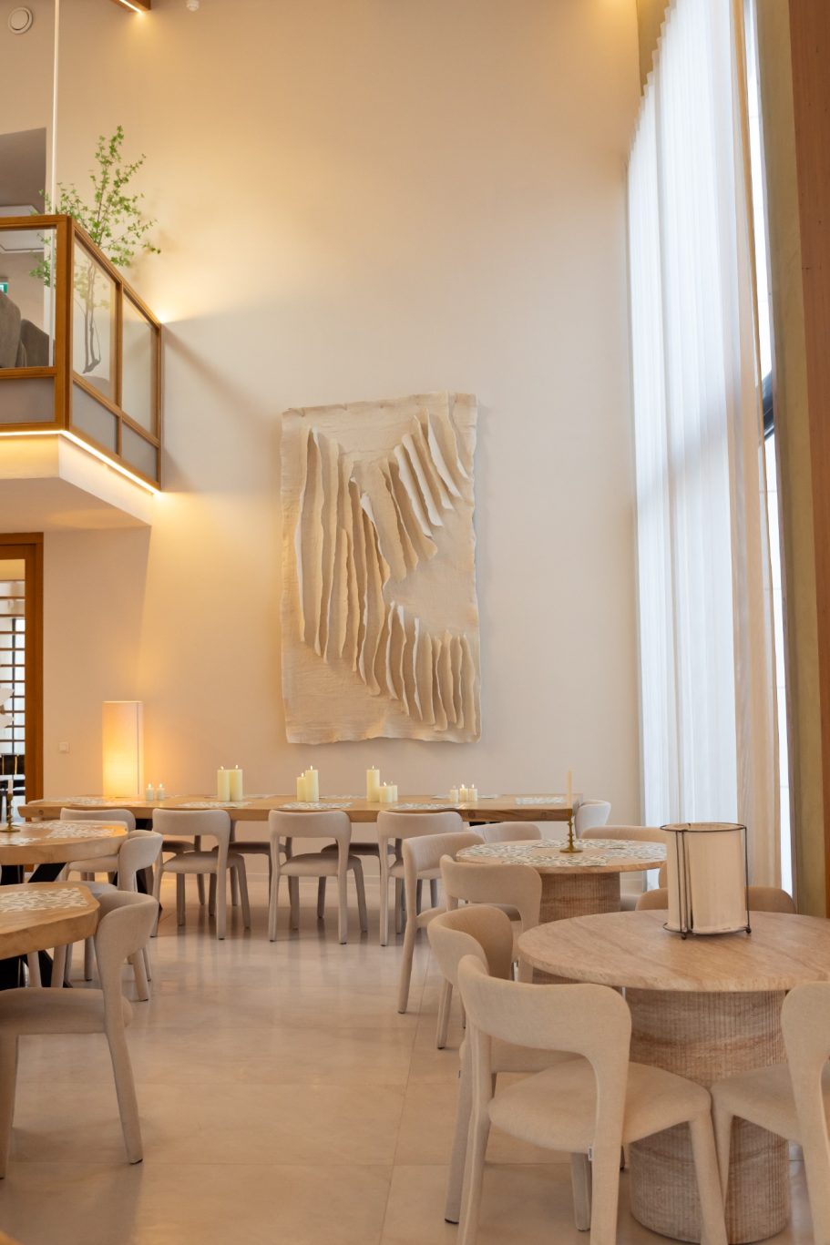 Minimalistisch ingericht restaurant met houten meubels en veel natuurlijk licht.