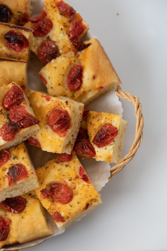 Geleverd brood met tomaten en kruiden, gesneden in kleine stukjes.
