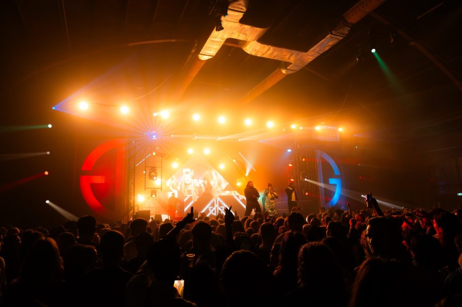 Een druk publiek met oplichtende lichten tijdens een live muziekoptreden.