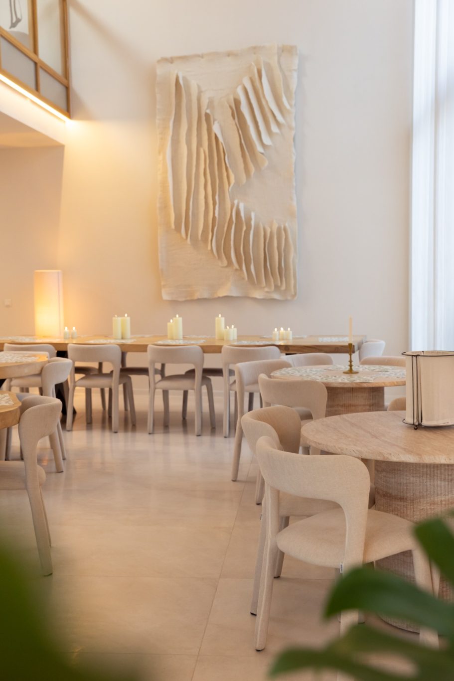 Moderne eetruimte met lichte meubels en een abstracte wanddecoratie.