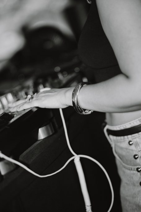 DJ H4zel - Geheime Liefde Festival Een DJ draait muziek met een hand op een draaitafel, terwijl een kabel zichtbaar is.