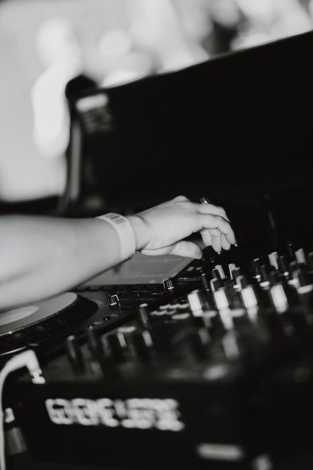 DJ H4zel - Geheime Liefde Festival Hand die een mixerdial bedient op een dj-console, met een onscherpe achtergrond.
