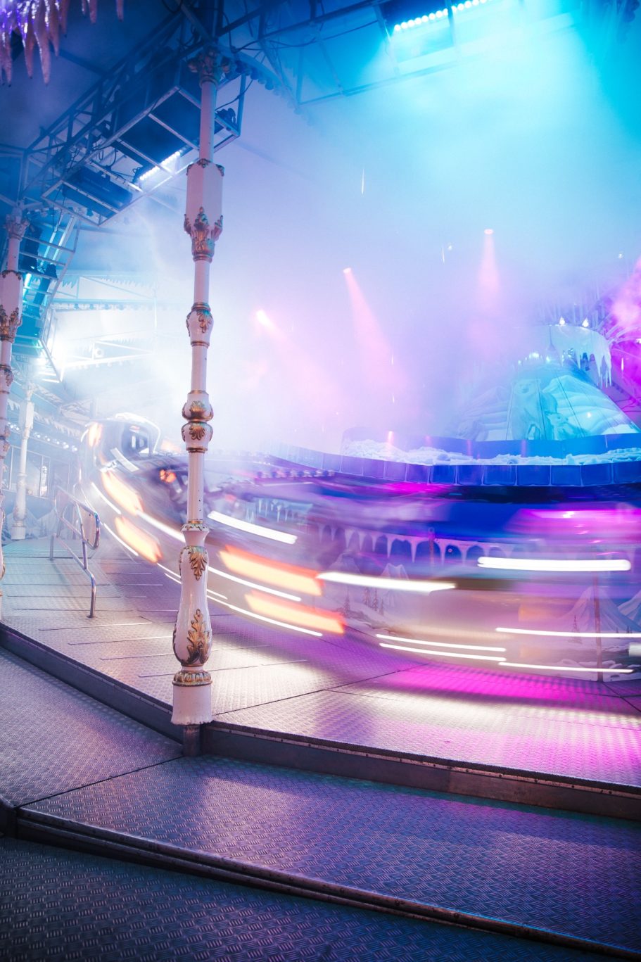 Een draaiende carrousel met kleurrijke lichten en mist effecten.