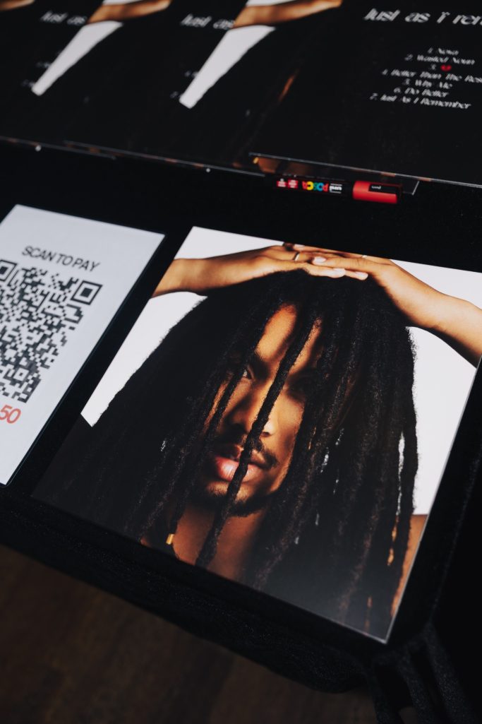 Jair Faria Bitterzoet Amsterdam Portret van een man met lange dreadlocks, handen op zijn hoofd.